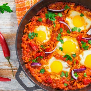 healthy breakfast shakshuka - fried eggs, tomato, pepper and spi